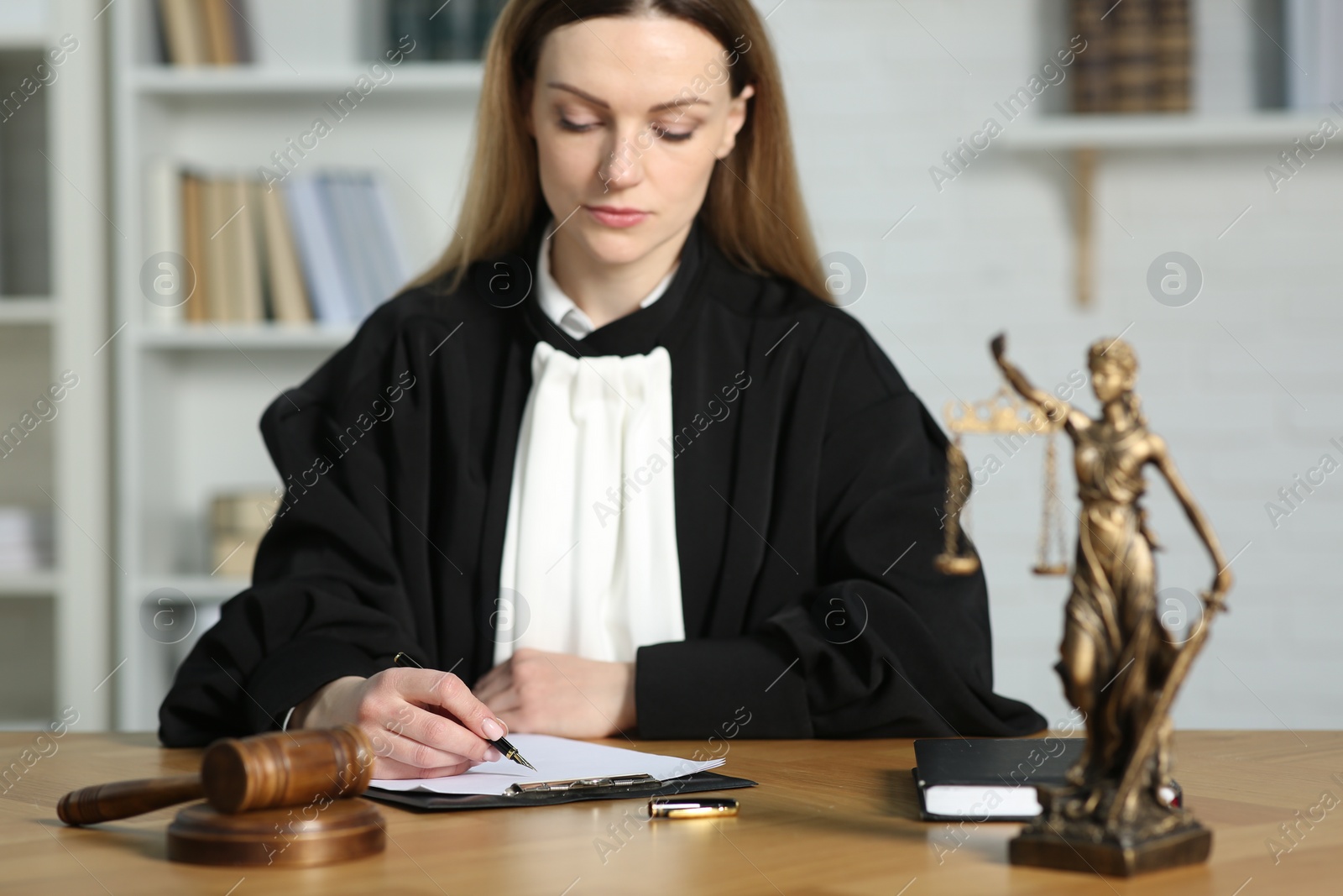 Photo of Judge working with document at table indoors