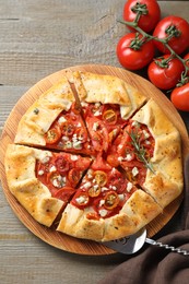 Photo of Tasty galette with tomato, rosemary and cheese (Caprese galette) on wooden table, top view