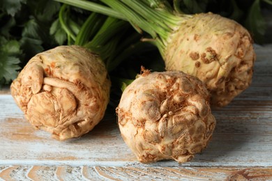 Fresh raw celery roots on wooden rustic table, closeup