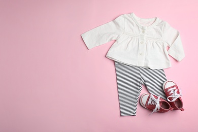 Flat lay composition with cute clothes and space for text on color background. Baby accessories
