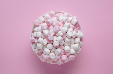 Photo of Bowl with delicious marshmallows on pink background, top view