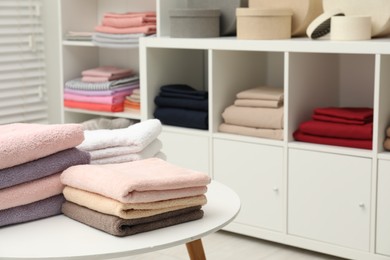 Photo of Stacked towels, decorative boxes and colorful bed linens in shop