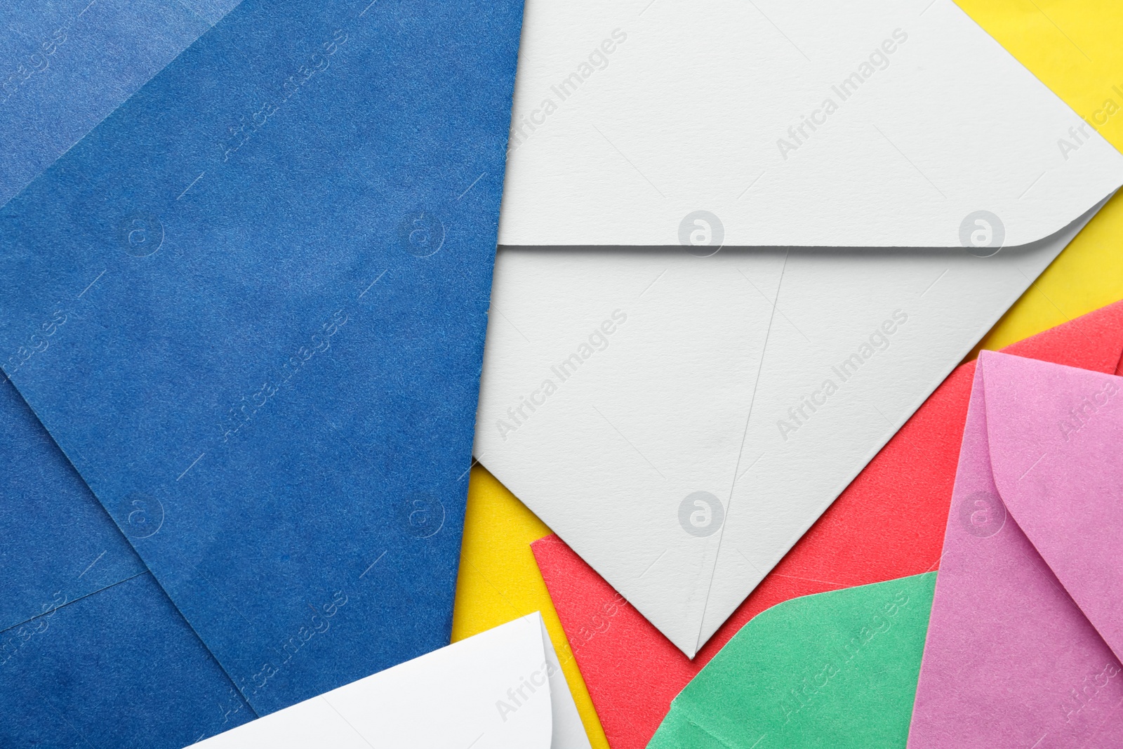 Photo of Colorful paper envelopes as background, top view