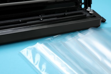 Photo of Sealer for vacuum packing with plastic bags on turquoise background,closeup