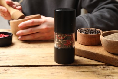 Photo of Ground pepper and grains on wooden table, selective focus. Space for text