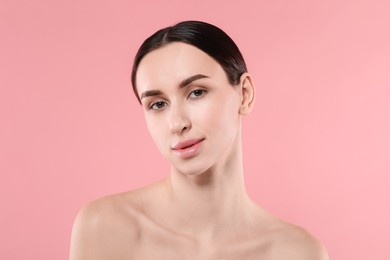 Portrait of beautiful young woman on pink background