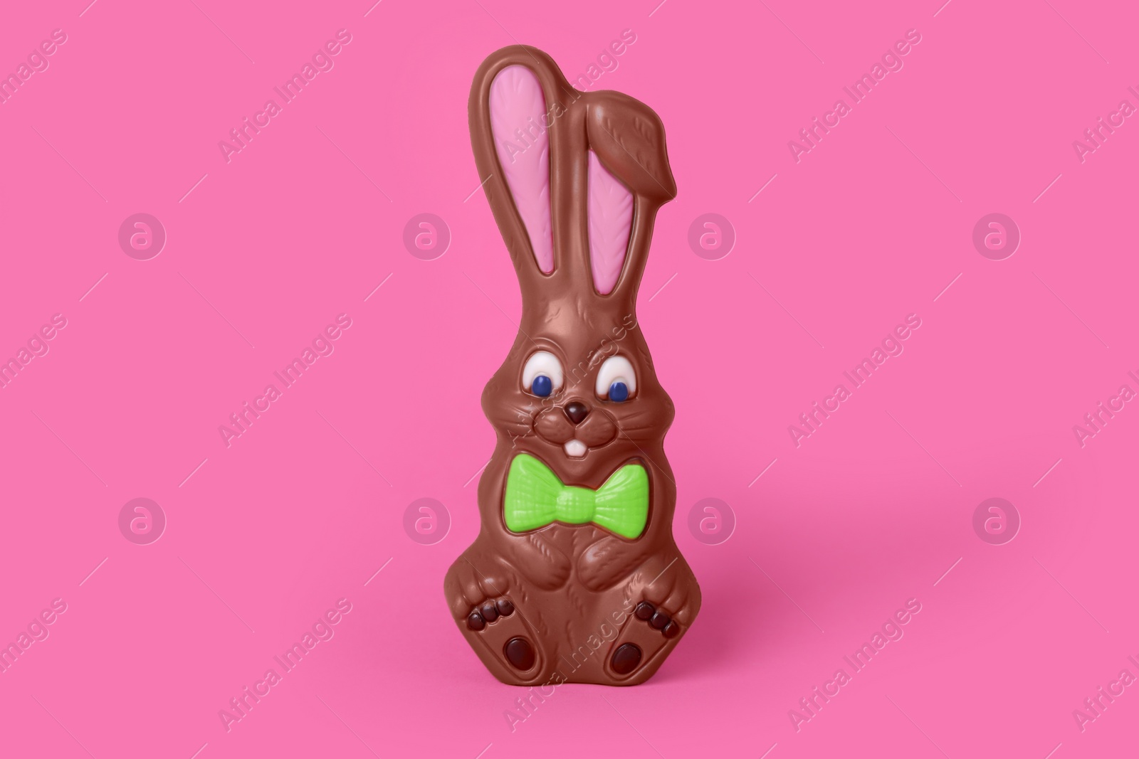 Photo of Chocolate bunny on pink background. Easter celebration