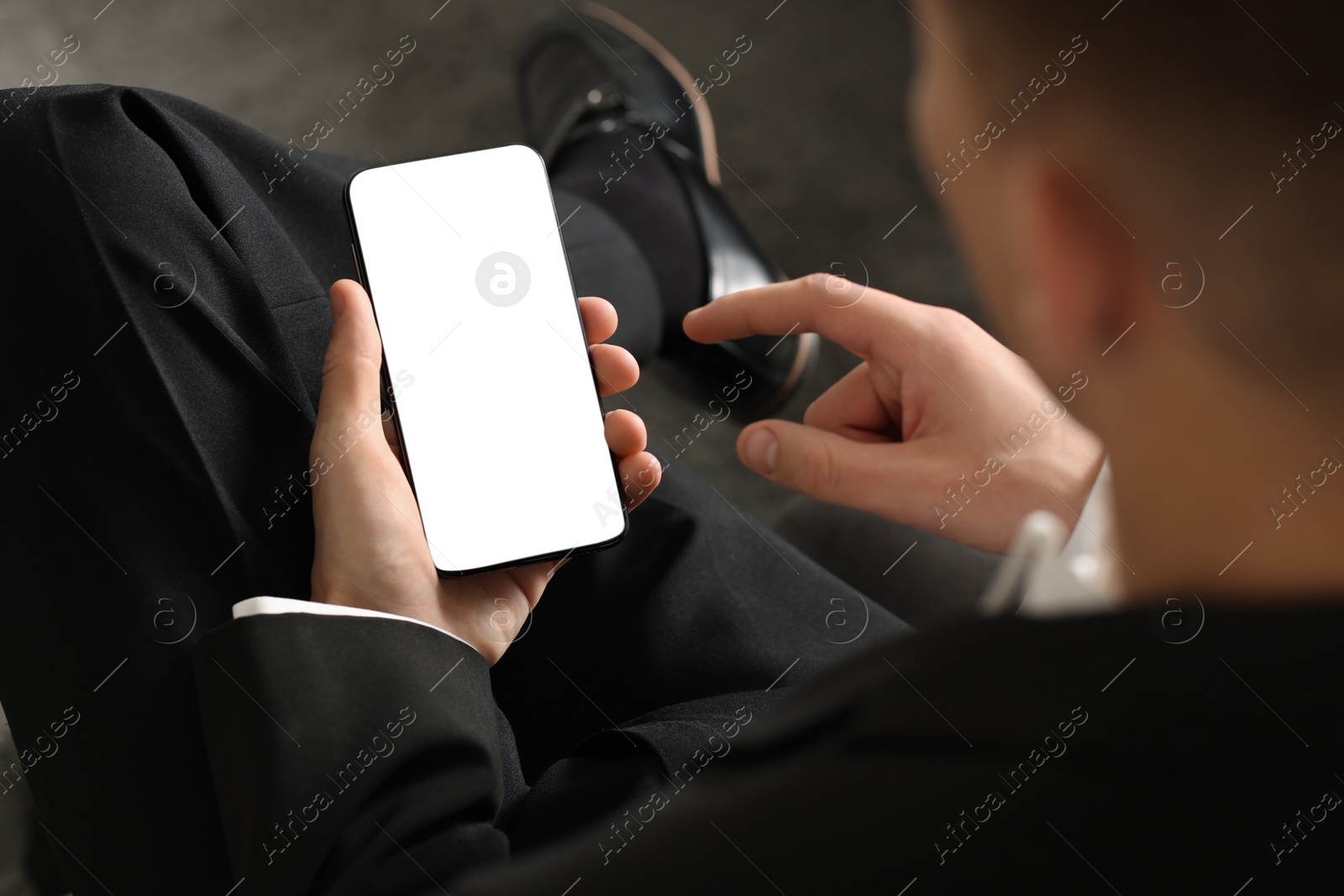 Photo of Man using smartphone with blank screen indoors, closeup. Mockup for design