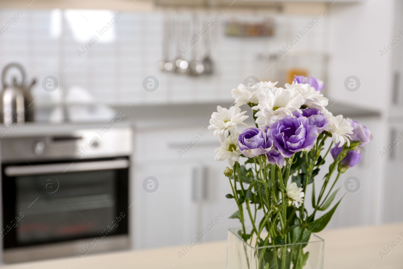 Photo of Vase with beautiful flowers in kitchen interior. Space for text