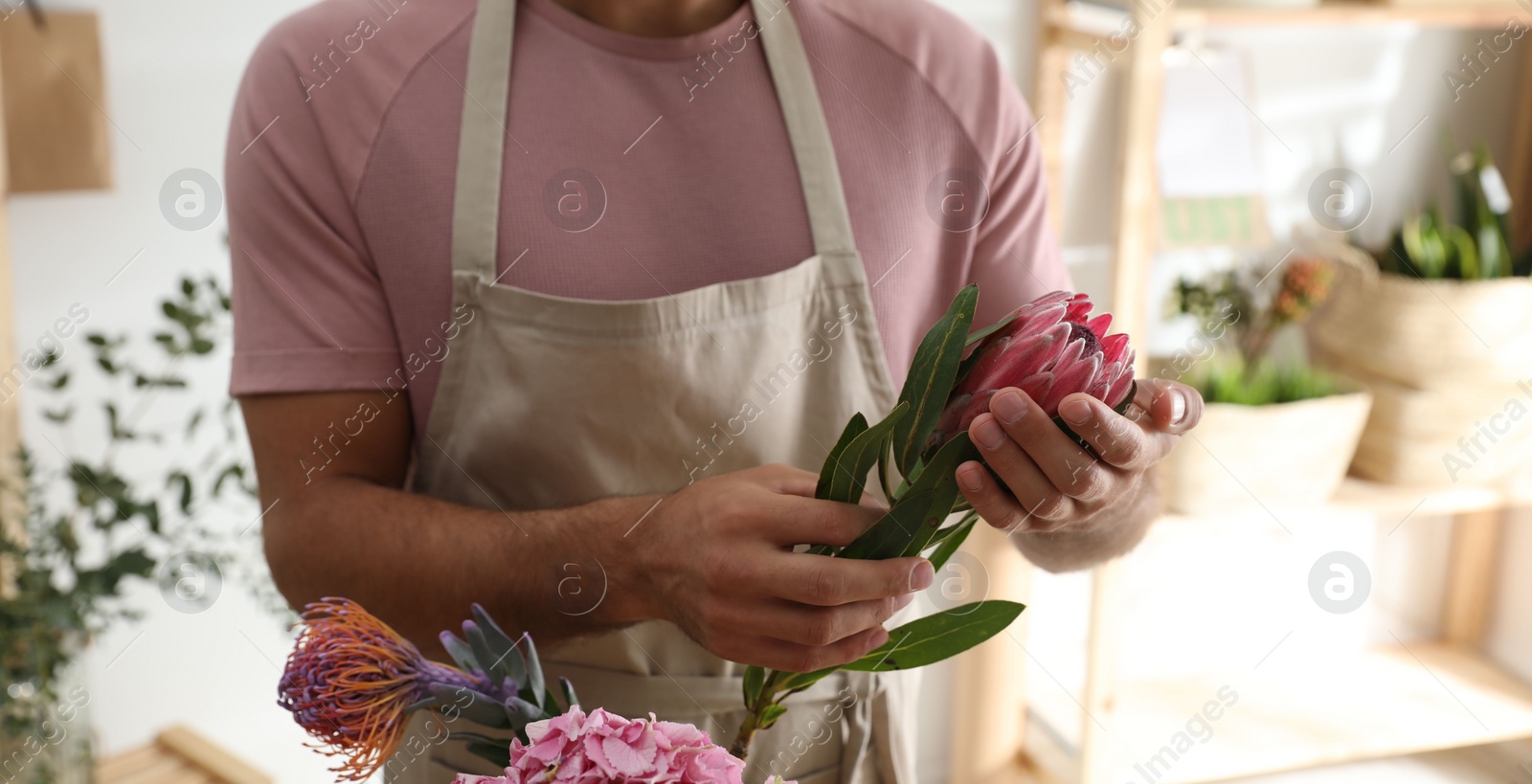 Photo of Florist with beautiful flowers in workshop, closeup