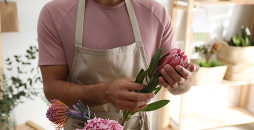 Florist with beautiful flowers in workshop, closeup