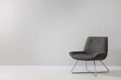Photo of Comfortable armchair near light grey wall indoors. Space for text