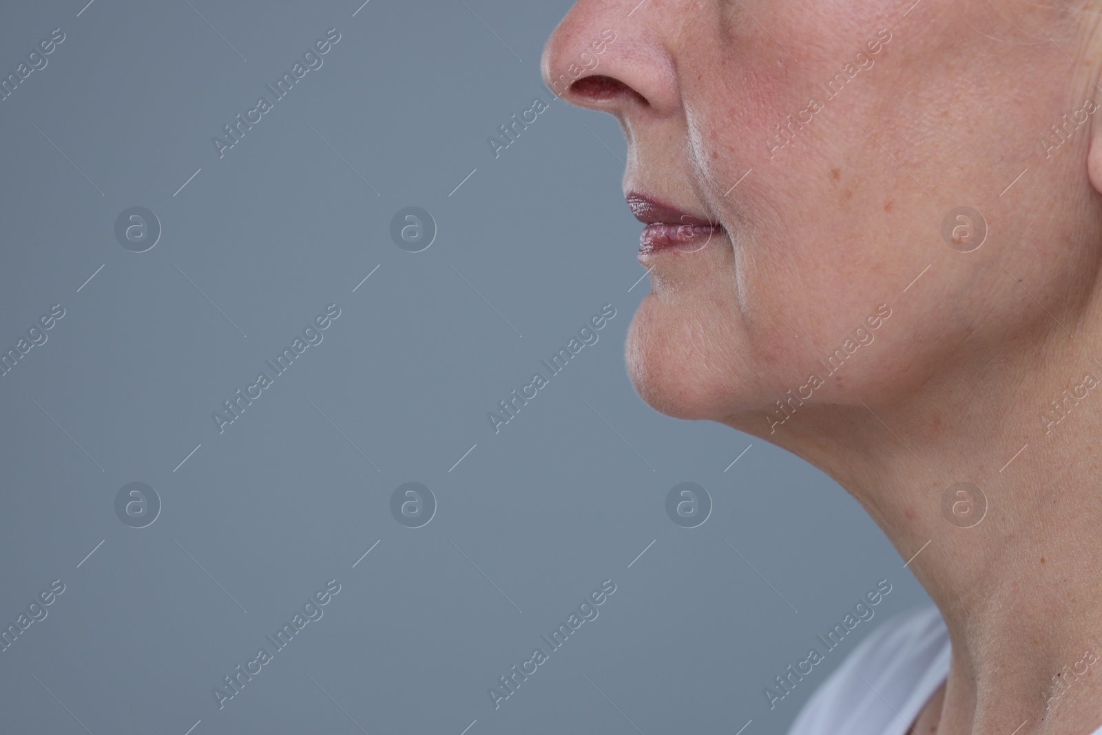 Photo of Senior woman with aging skin on grey background, closeup and space for text. Rejuvenation treatment