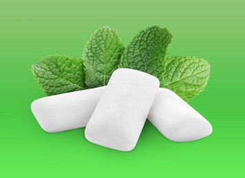 Menthol chewing gum pillows and mint leaves on green gradient background