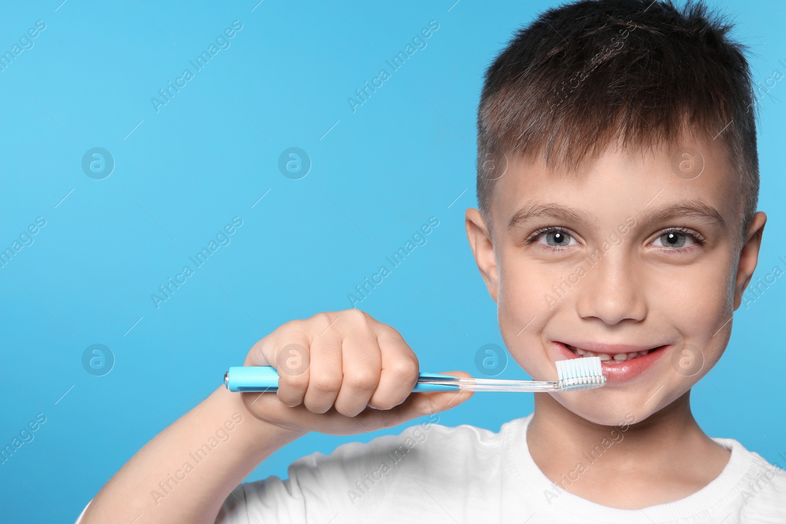 Photo of Portrait of little boy with toothbrush on color background. Space for text