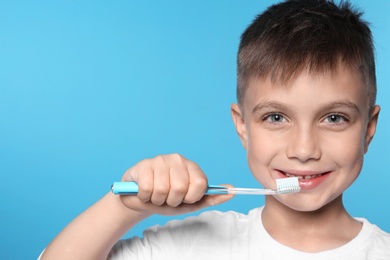 Photo of Portrait of little boy with toothbrush on color background. Space for text