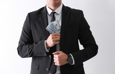 Photo of Man with bribe money on light background, closeup