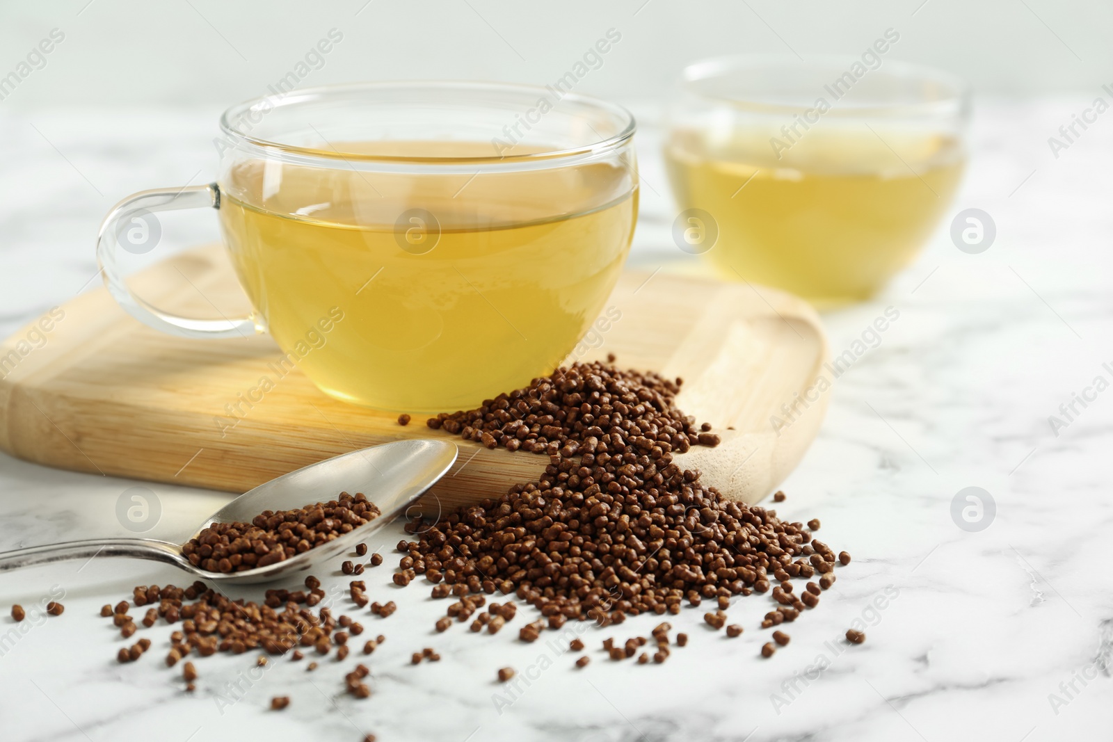 Photo of Buckwheat tea and granules on white marble table