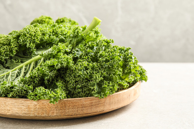 Fresh kale leaves on light grey table, closeup