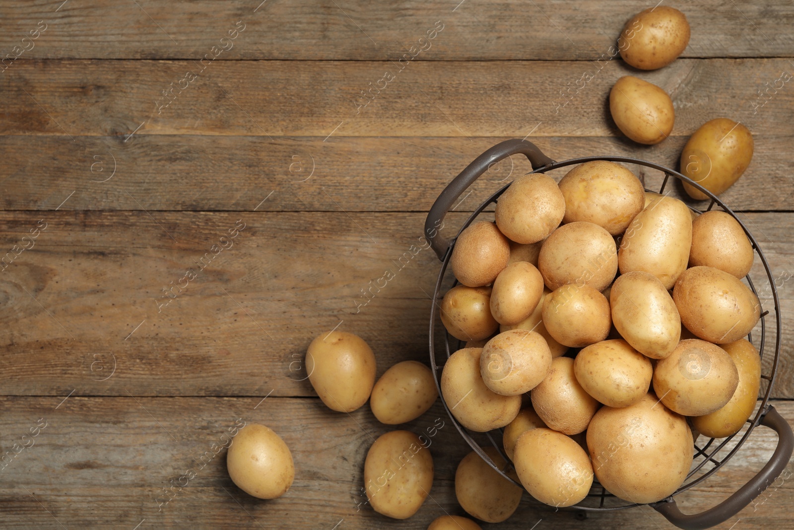 Photo of Raw fresh organic potatoes on wooden background, top view. Space for text