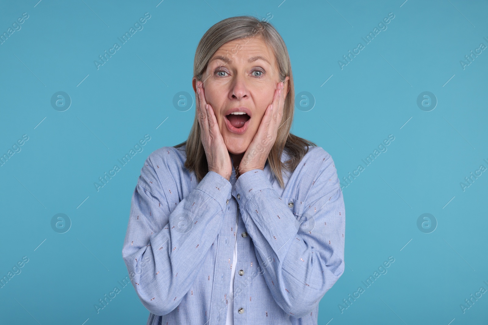 Photo of Portrait of surprised senior woman on light blue background