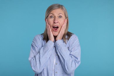 Photo of Portrait of surprised senior woman on light blue background