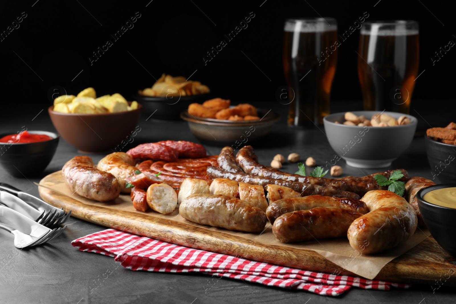 Photo of Set of different tasty snacks on dark grey table