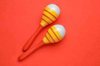 Photo of Maracas on red background, top view. Musical instrument