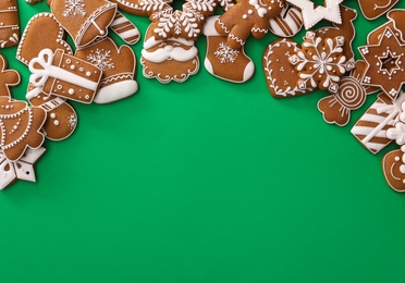 Photo of Different Christmas gingerbread cookies on green background, flat lay. Space for text