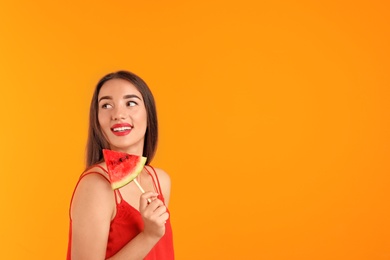 Beautiful young woman posing with watermelon on color background