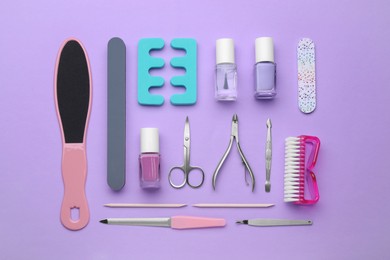 Set of pedicure tools on violet background, flat lay