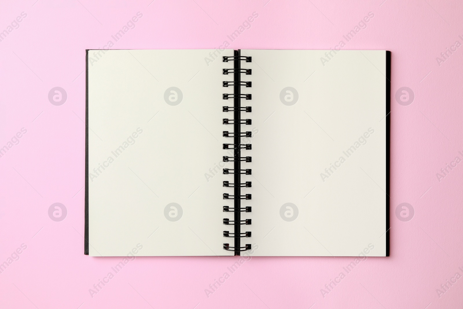 Photo of Blank notebook on pale pink background, top view