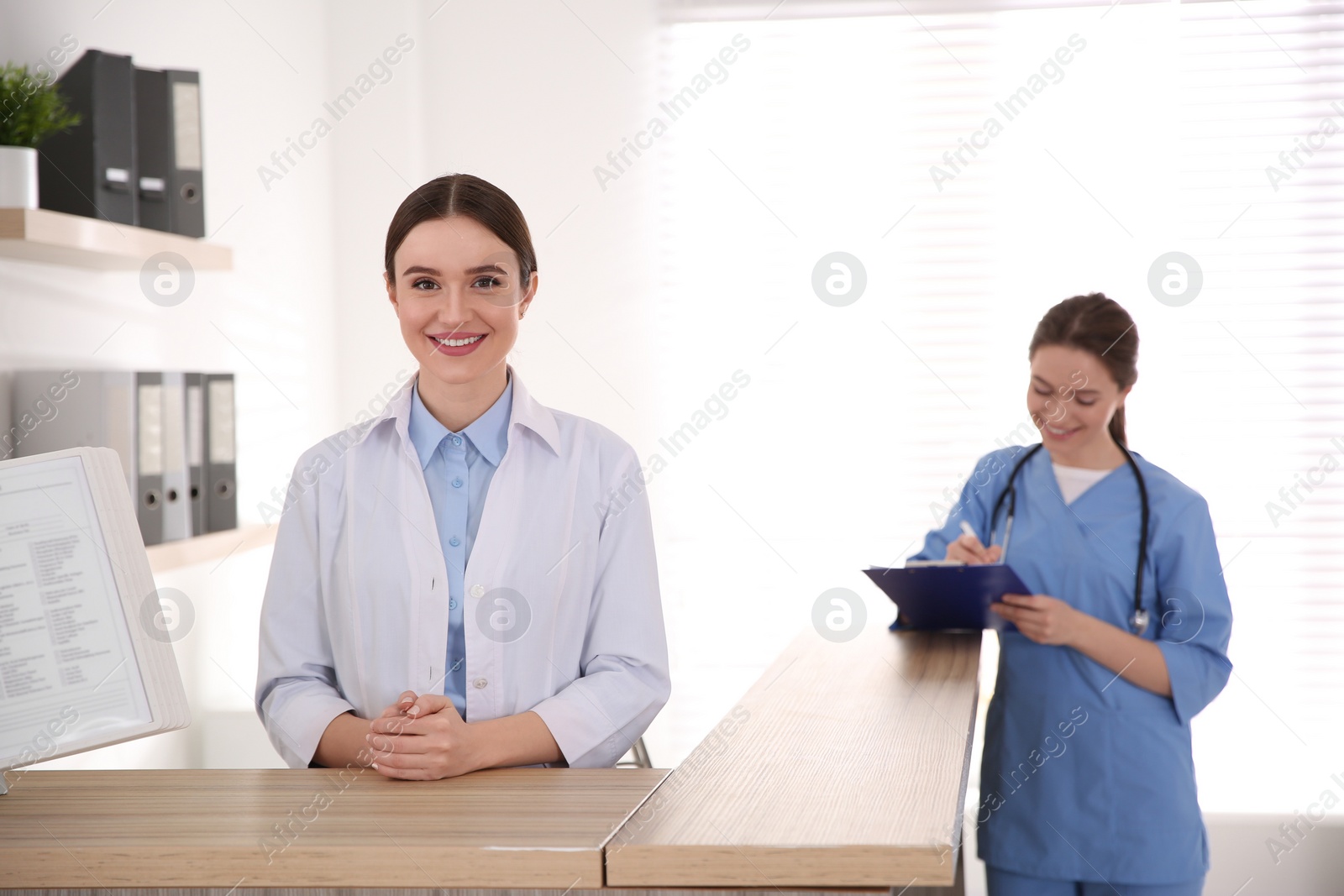 Photo of Portrait of female doctor at counter in modern clinic