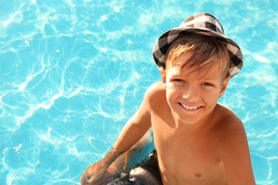 Happy cute boy with hat in swimming pool