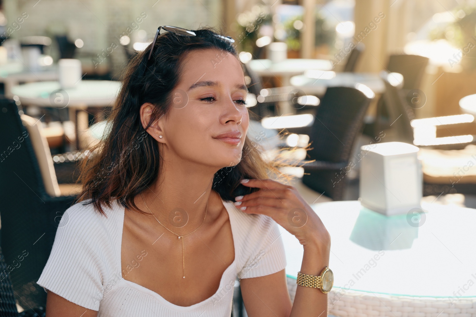 Photo of Portrait of happy young woman in outdoor cafe