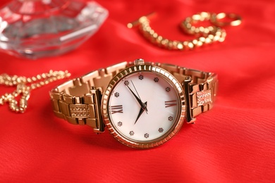 Photo of Luxury wrist watch on red background, closeup