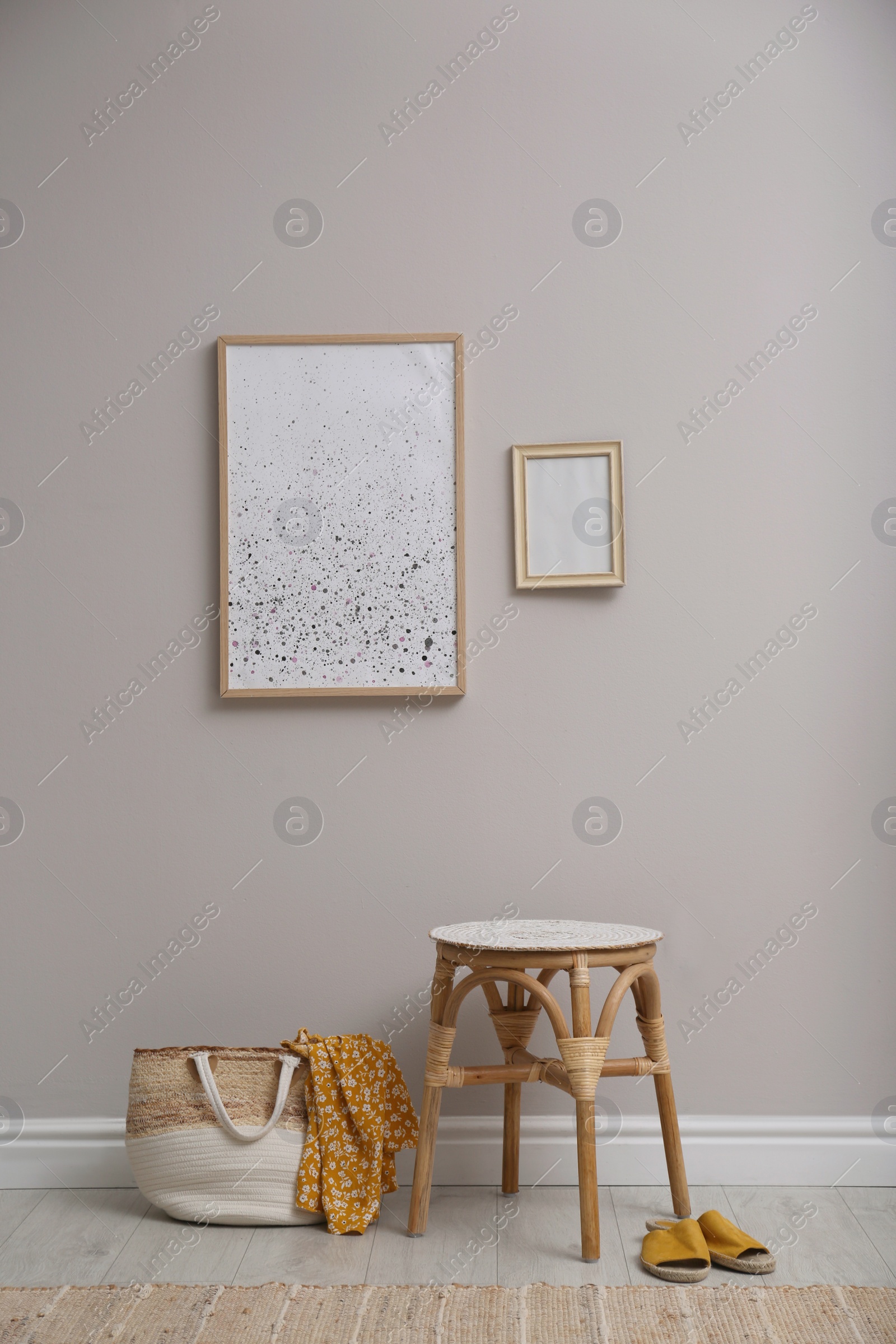 Photo of Wooden stool and bag near light grey wall indoors. Interior accessories