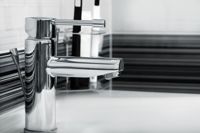 Image of Clean white sink with shiny water tap in bathroom