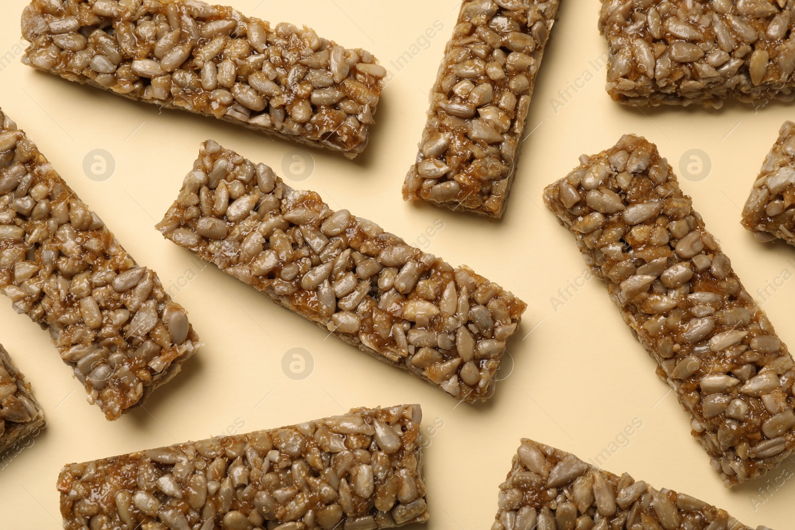 Photo of Delicious kozinaki bars on beige background, flat lay