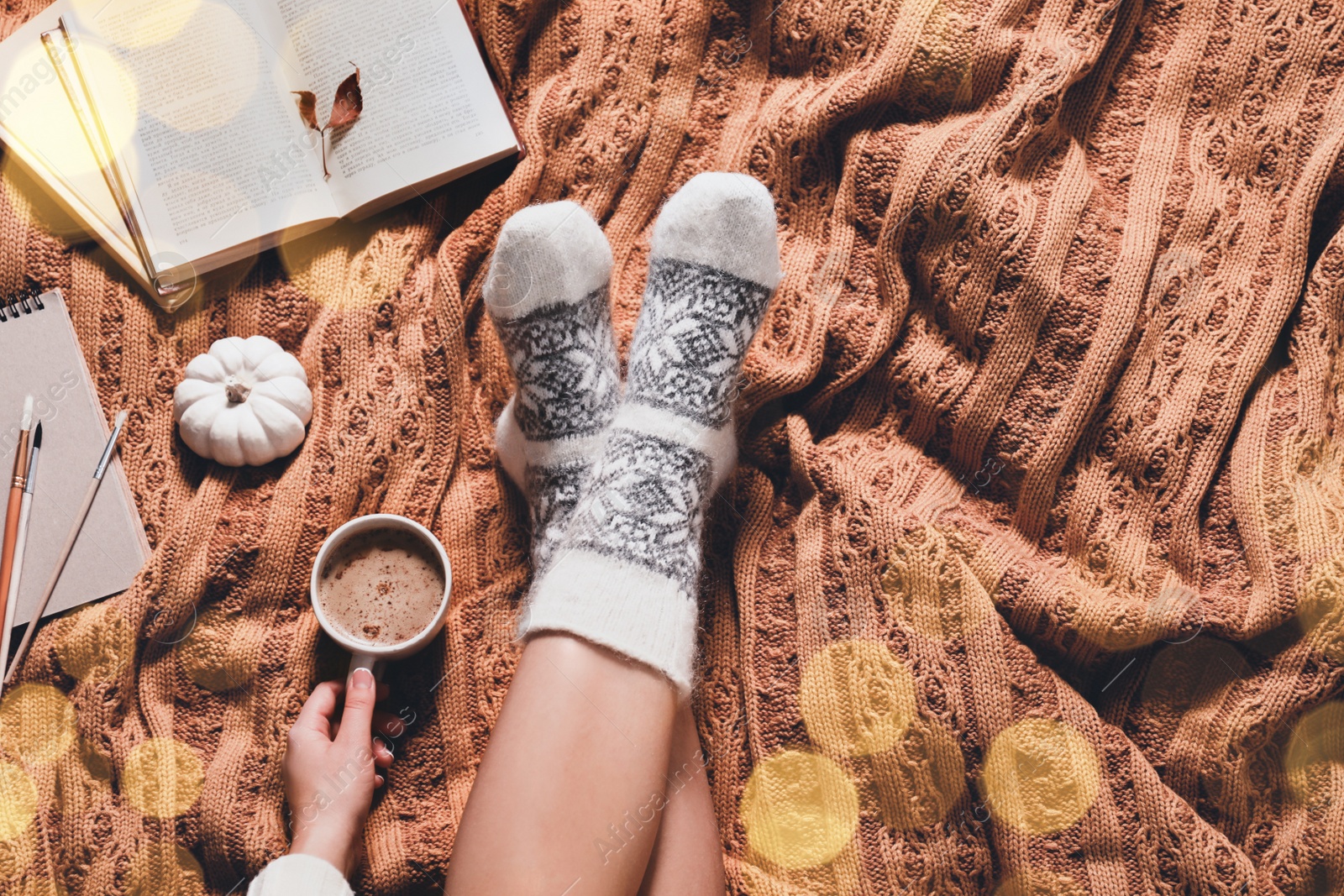 Image of Woman in warm socks resting on soft plaid, top view. Space for text