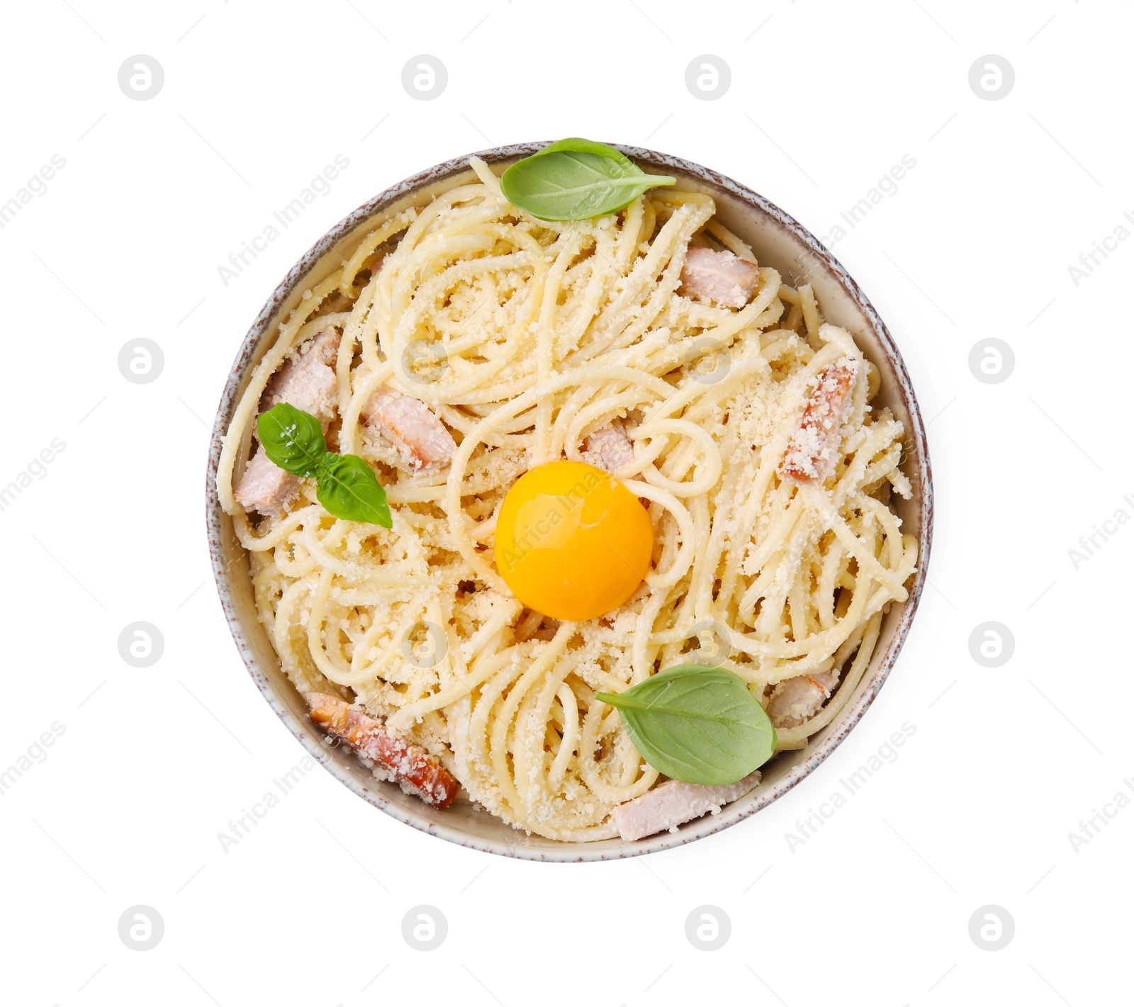 Photo of Bowl of tasty pasta Carbonara with basil leaves and egg yolk isolated on white, top view