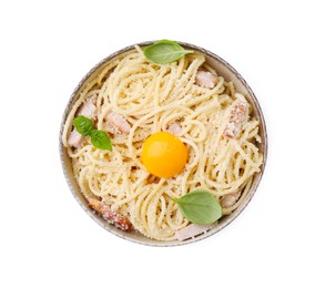 Photo of Bowl of tasty pasta Carbonara with basil leaves and egg yolk isolated on white, top view