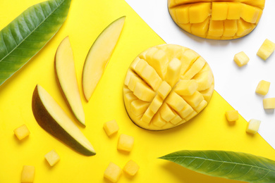 Flat lay composition with cut fresh ripe mango fruits on color background