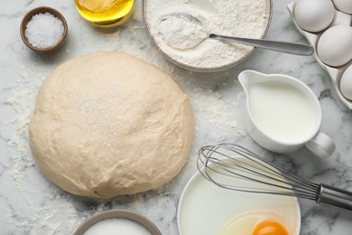 Photo of Fresh yeast dough and ingredients on white marble table, flat lay