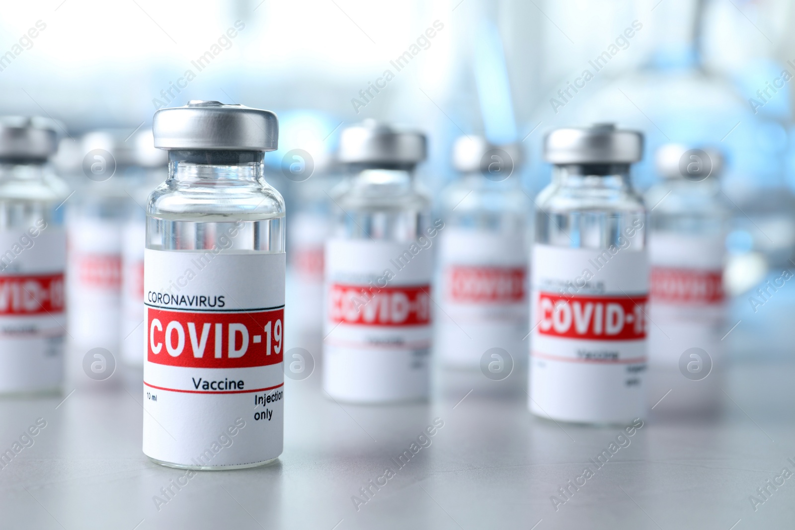 Photo of Glass vials with COVID-19 vaccine on light table