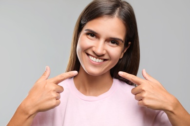 Photo of Young woman with healthy teeth on light background. Cosmetic dentistry