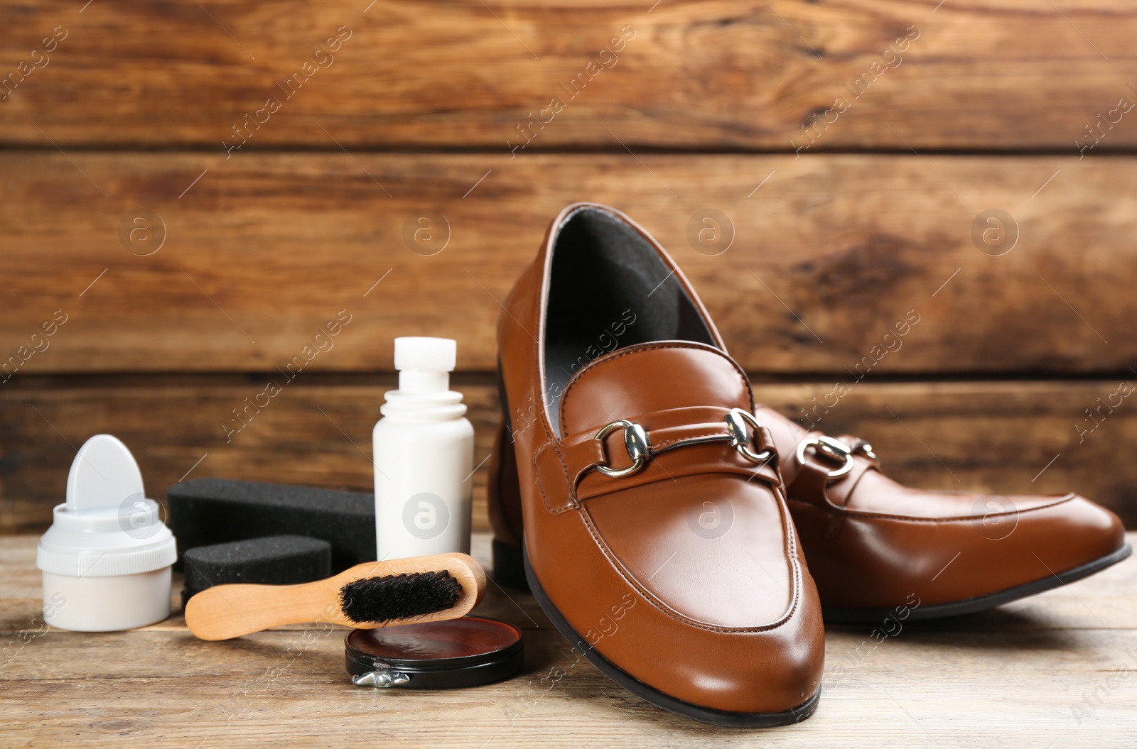 Photo of Shoe care accessories and footwear on wooden table