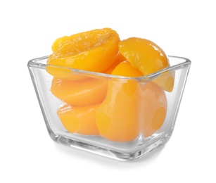 Photo of Bowl with halves of canned peaches on white background