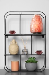 Photo of Shelving unit with decorative elements on chest of drawers. Interior design