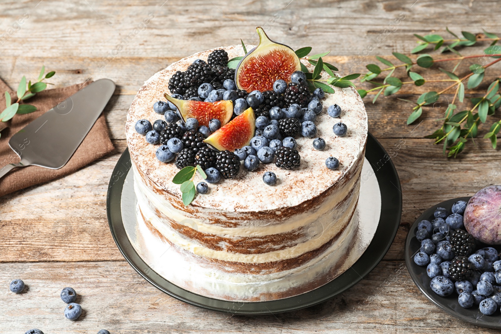 Photo of Delicious homemade cake with fresh berries served on wooden table